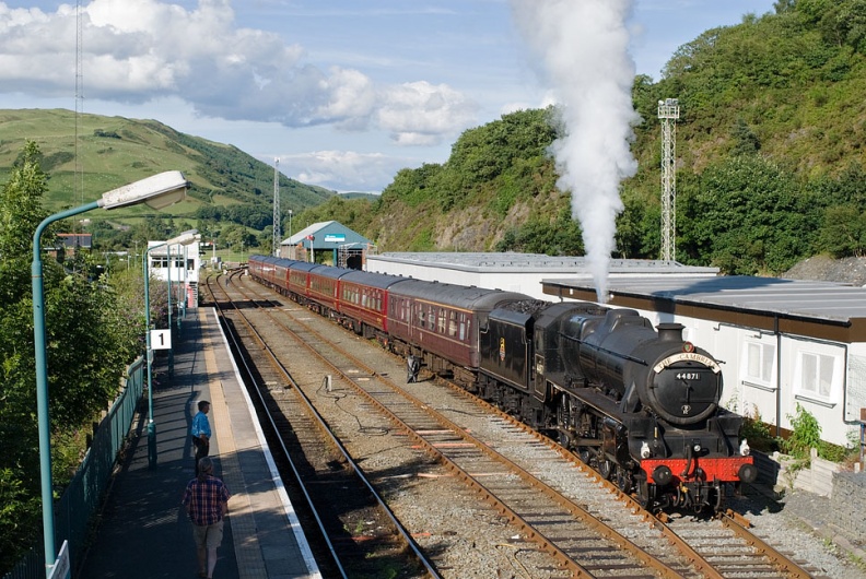 33207 “Jim Martin” draws the 5Z69 10.35 Carnforth to Machynlleth into the tank sidings at Machynlleth, prior to starting the Cambrian summer steam season the following Monday. LMS Class 5MT 4-6-0 no. 44871 is seen here on the rear of the train. The locomotive is carrying the cast "The Cambrian" headboard. flickr-welsh snapper-4822160828.jpg